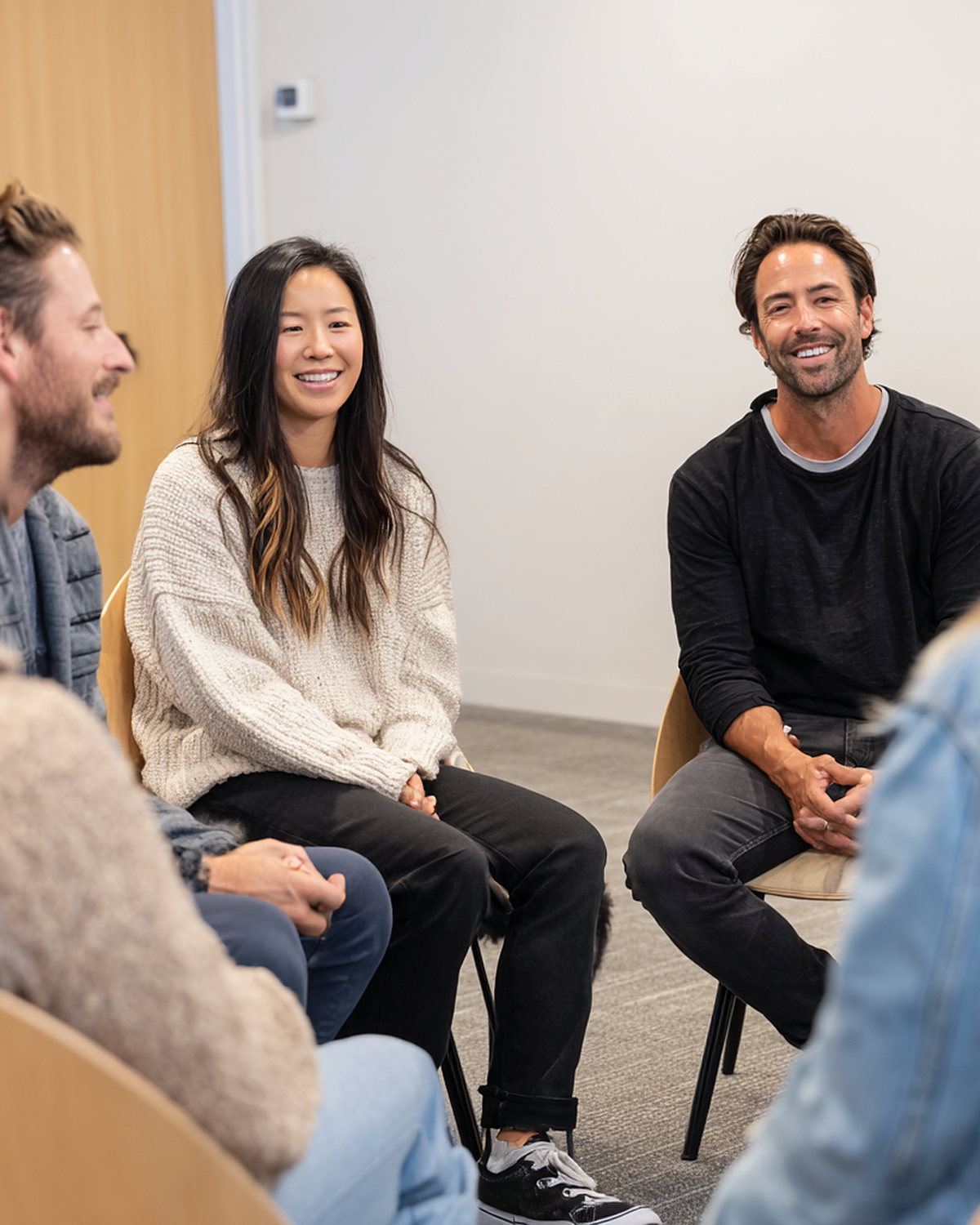 Young adults laughing together in a circle